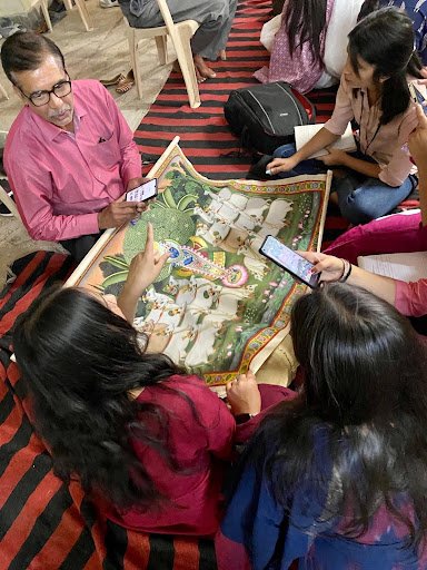 Fashion textiles students from Amity School of Fashion Technology, Jaipur, discuss a traditional Gopashtami pichvai with artist Shyam Sharma and lean in to observe Parmanand Sharma sketching. Fashion textiles students from Amity School of Fashion Technology, Jaipur, discuss a traditional Gopashtami pichvai with artist Shyam Sharma and lean in to observe Parmanand Sharma sketching.